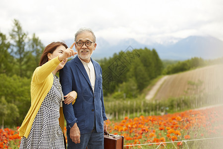 田野间挽手游玩的夫妇背景图片