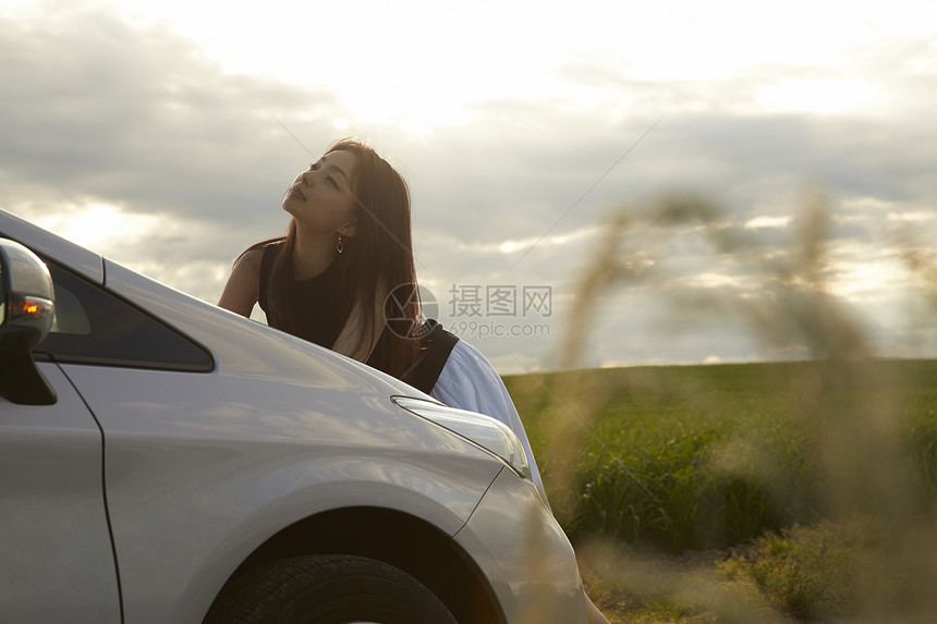 女人在车边看乡间风景图片