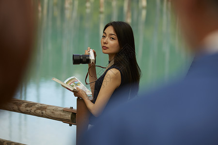 在湖边拍风景照的女性图片