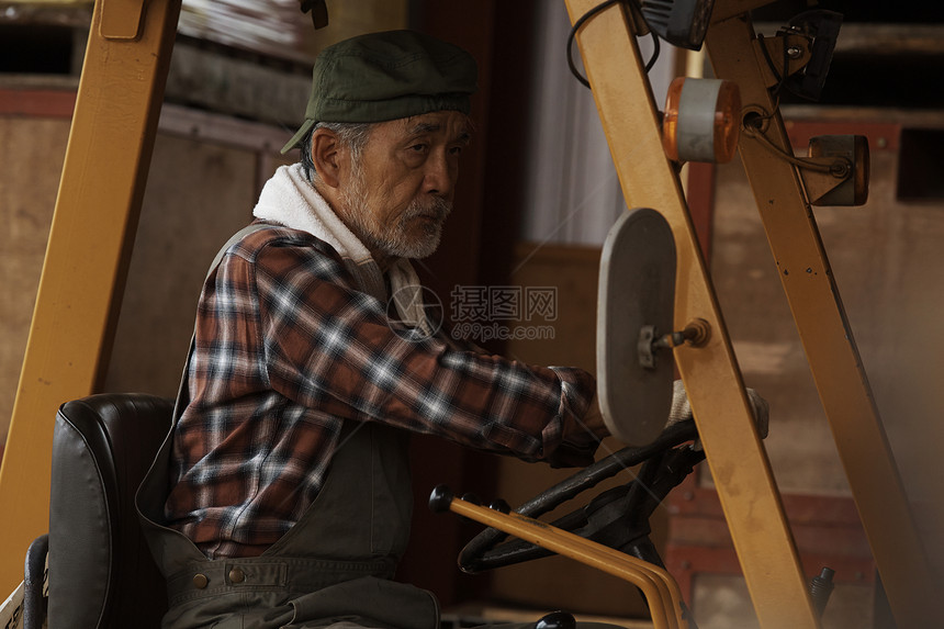 一名老农夫驾驶一辆拖拉机图片