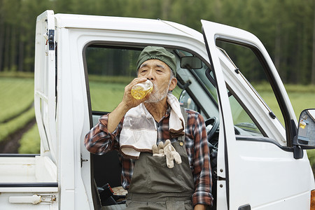 坐在车里休息喝水的农民图片