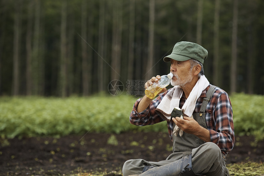 坐在田间吃饭的农夫图片