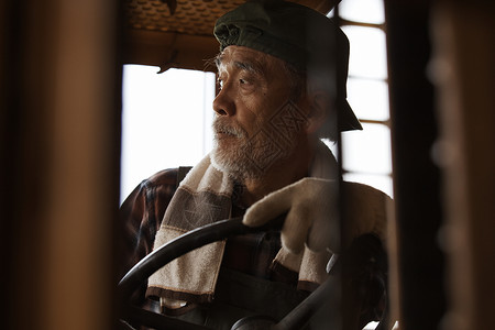 驾驶拖拉机的老年农夫图片