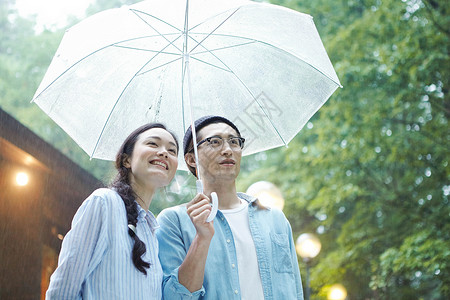 雨天撑伞漫步林间的情侣图片
