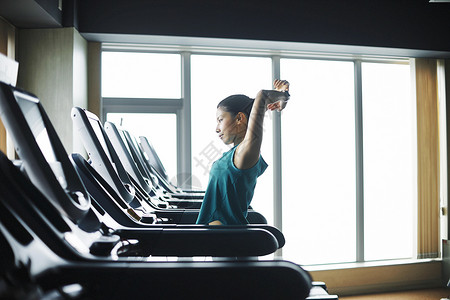 在健身房使用跑步机的女子图片