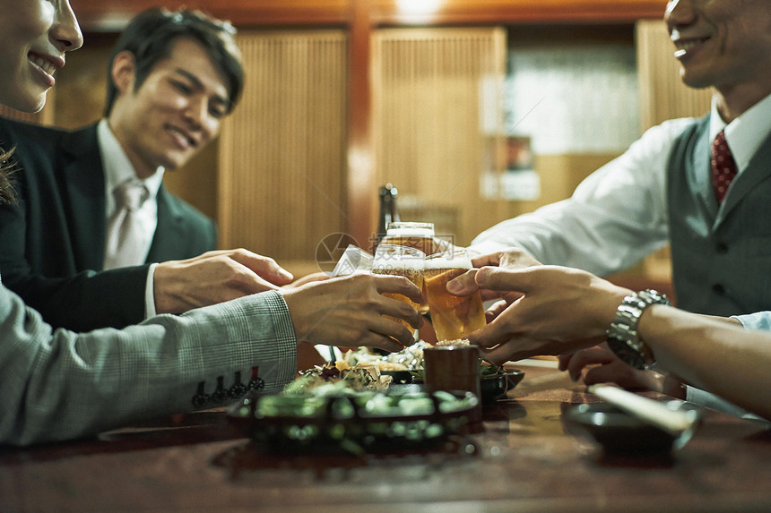 居酒屋里三个男商人碰杯特写 图片