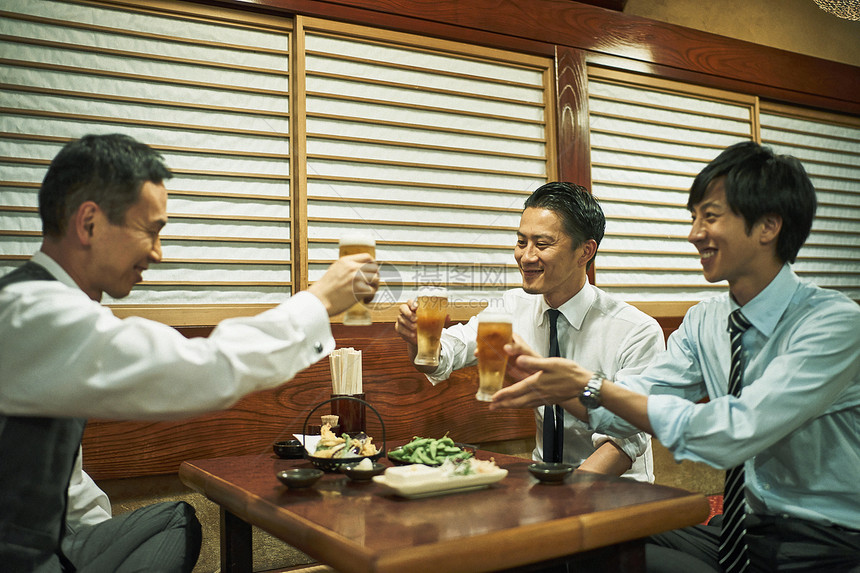 商务人士在居酒屋喝酒交谈图片