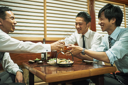 商务人士在居酒屋碰杯图片