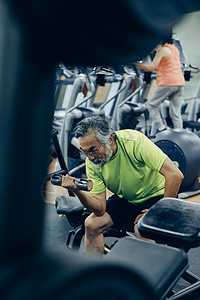 在健身房锻炼手臂的中年人图片