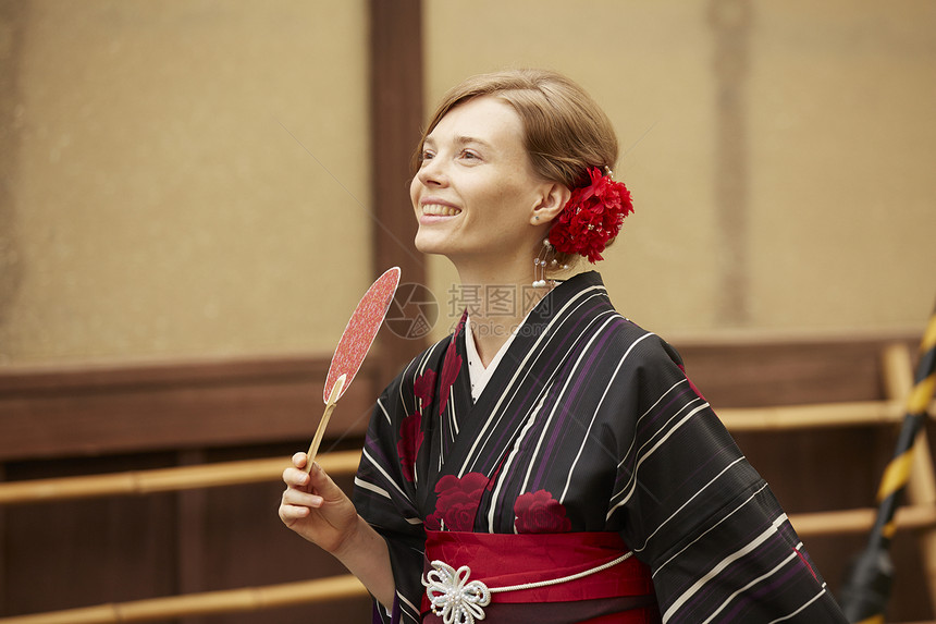穿日式和服拿着扇子游玩的女性肖像图片