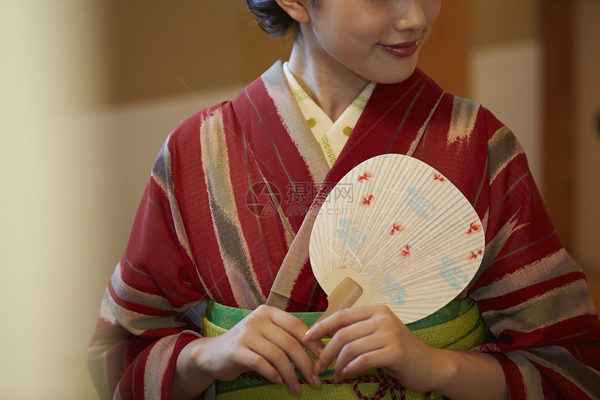 室内优雅拿扇子的穿和服的女性肖像图片