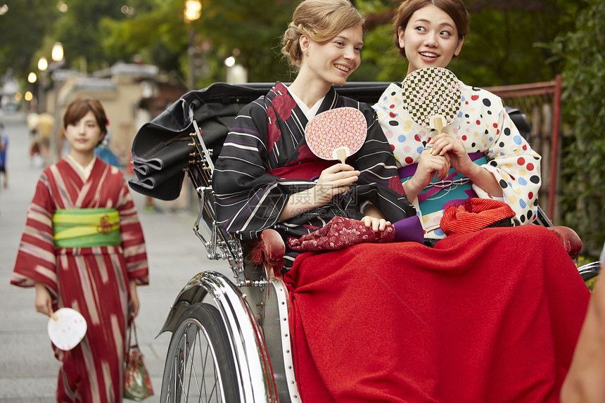 年轻美女带外国友人乘坐人力车图片