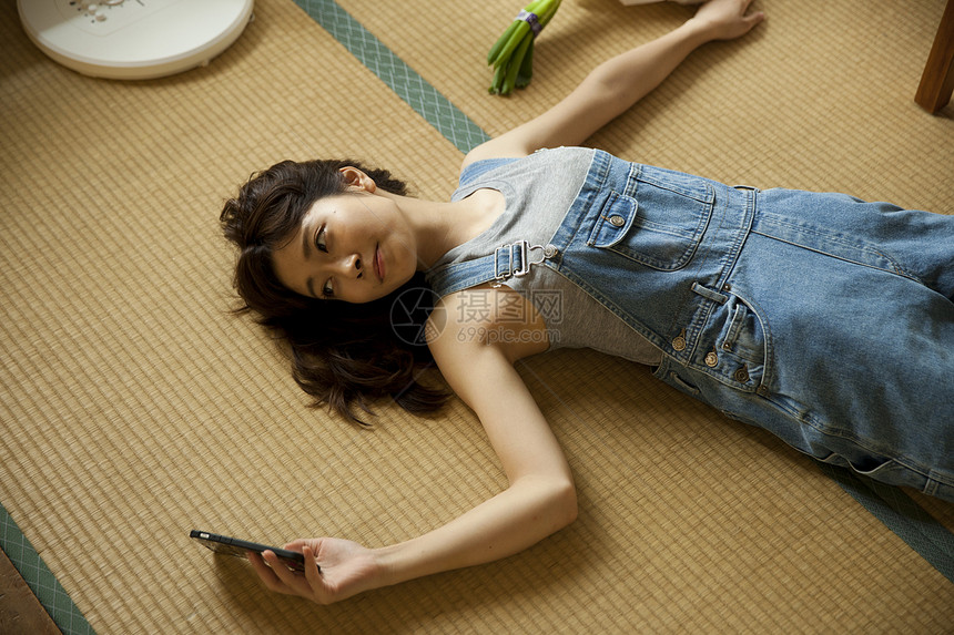 躺在地上乘凉看手机的女孩图片