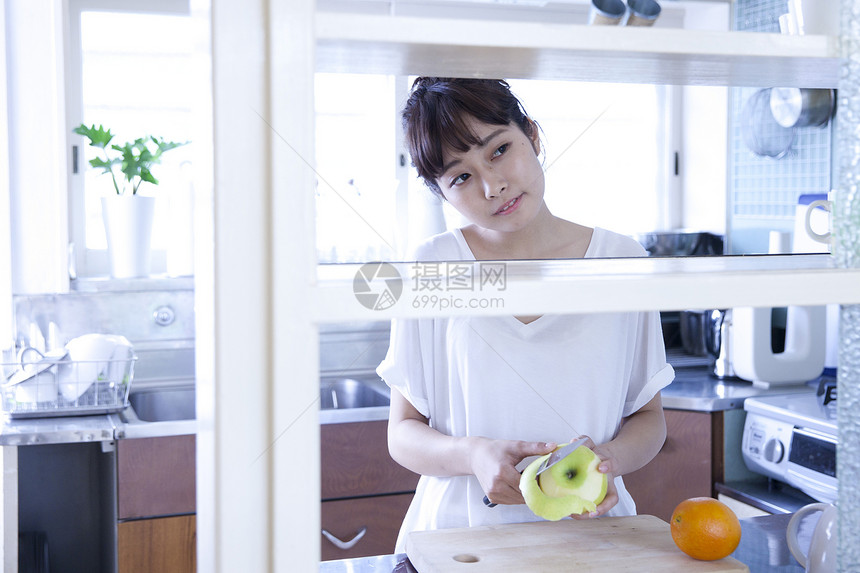 厨房水果削皮的居家女性图片