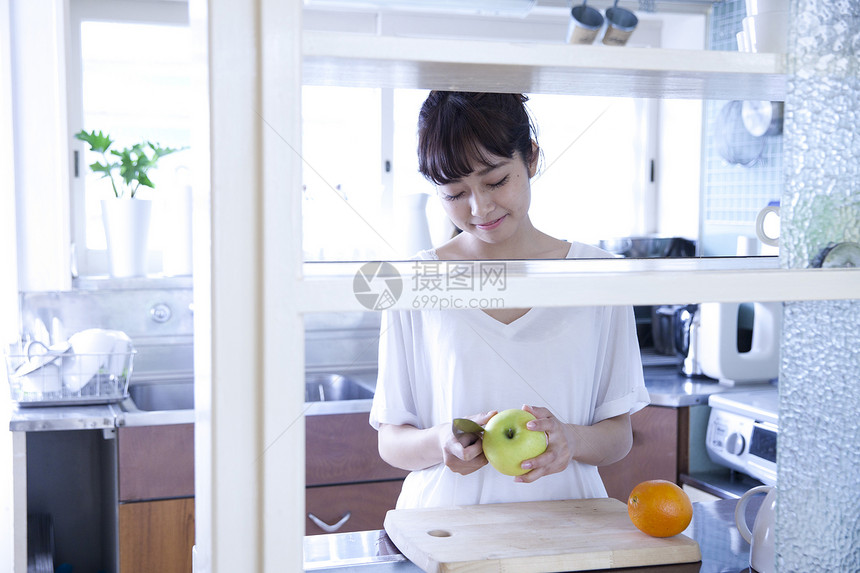 厨房水果削皮的居家女性图片