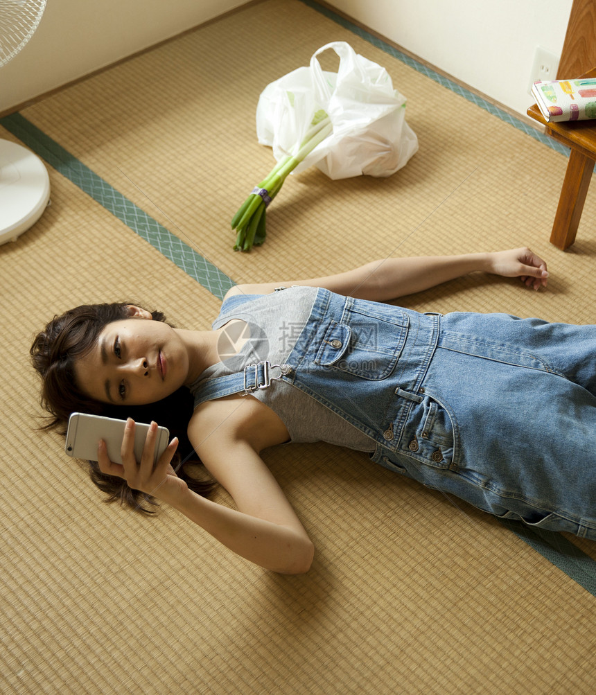 居家女性躺在地上刷手机图片