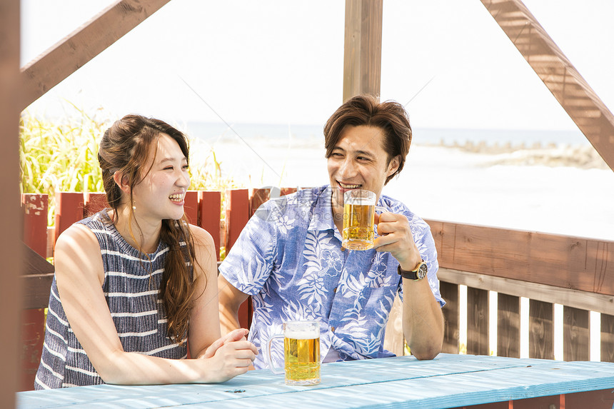海边喝啤酒的情侣图片