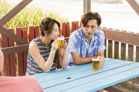 海边喝啤酒的情侣图片
