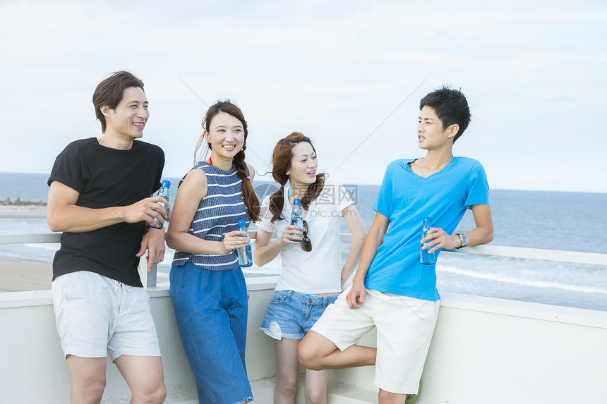 海边喝酒的青年情侣图片