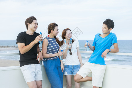 坐在海边喝酒聊天的青年旅客住宿于私家住宅高清图片素材