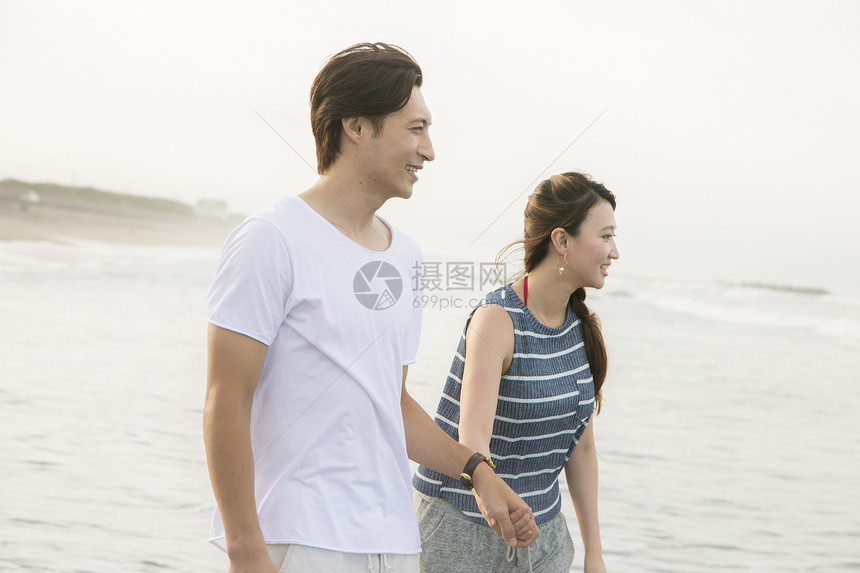在海滩上行走的情侣图片