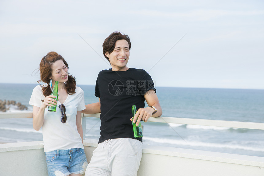 海边还啤酒的情侣图片
