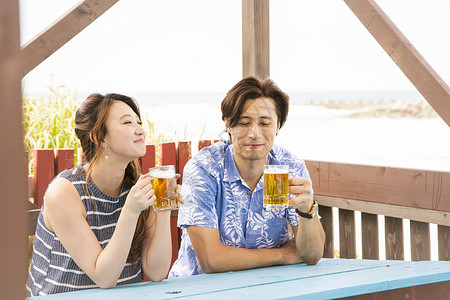 夏日海边喝酒聊天的情侣恋人高清图片素材