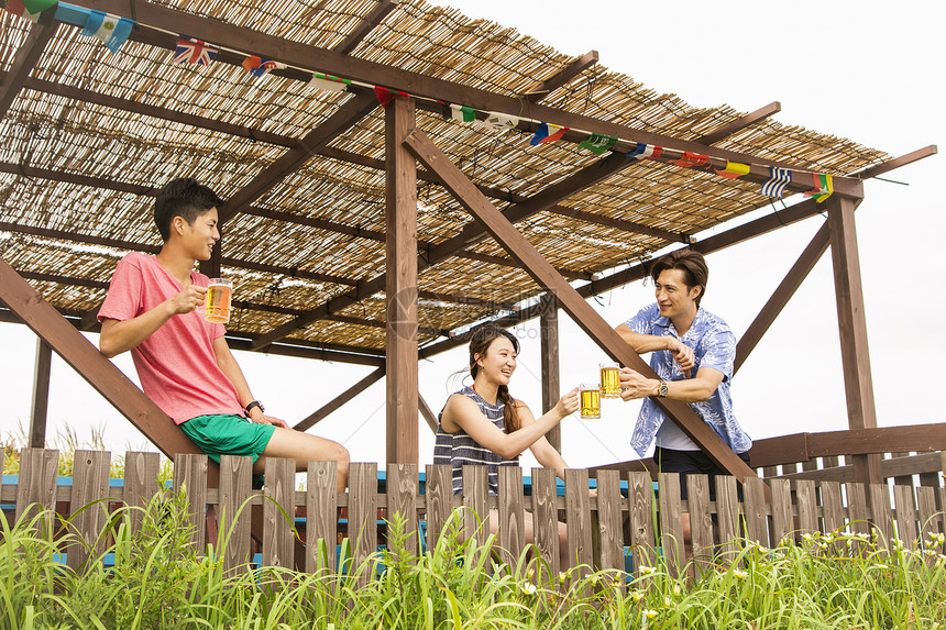 3人夏日海边喝酒聊天图片