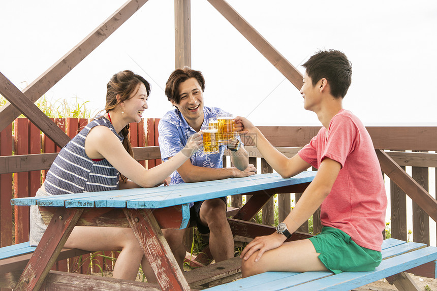 3人夏日海边喝酒聊天图片