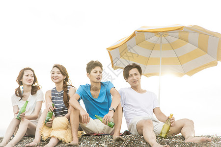 夏日坐在海滩边旅游聚会的4人图片