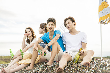 夏日坐在海滩边旅游聚会的4人暑假高清图片素材
