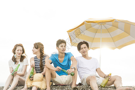 夏日坐在海滩边旅游聚会的4人热情高清图片素材