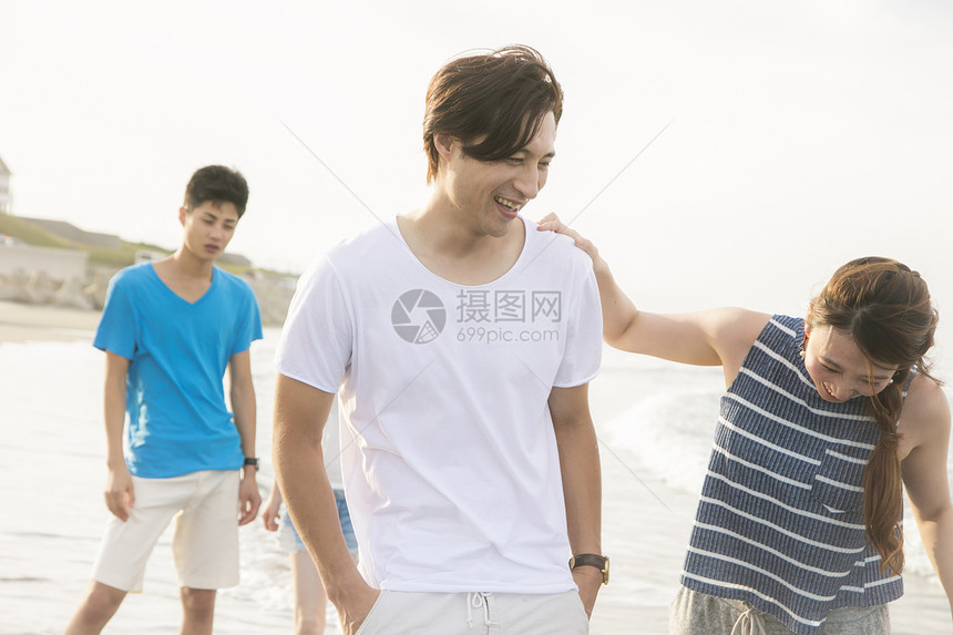 海滩边散步的年轻人图片