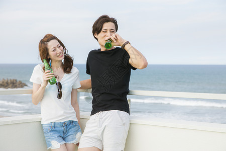 海边天台上情侣度假喝酒享受快乐的高清图片素材