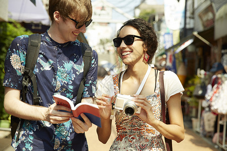 户外旅游的外国情侣看旅游手册图片