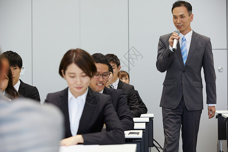 宣讲会上引导职员填写资料的男人背景图片