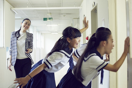 课间路过学校走廊玩闹女学生的老师图片