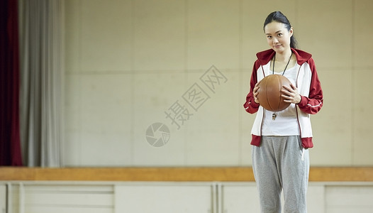 室内篮球场拿着篮球的女教练肖像图片