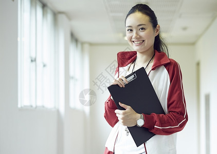 楼道间手持教案微笑的女老师图片