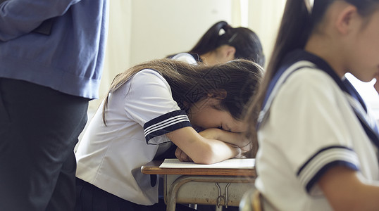 好课提前购趴在课桌上睡觉的女学生背景