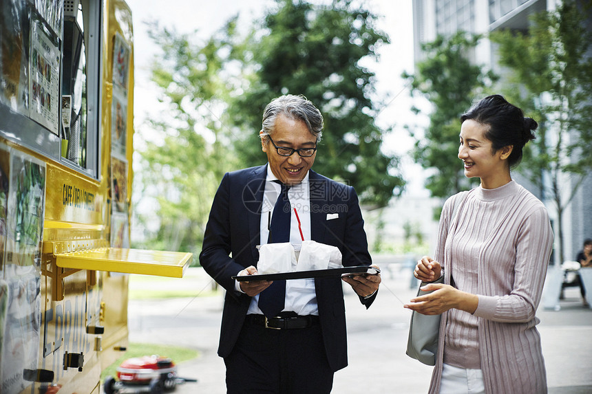 商业伙伴在城市公园买午餐图片