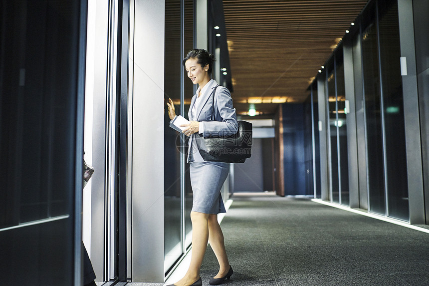 三十几岁女企业家走入办公楼电梯图片