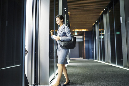 三十几岁女企业家走入办公楼电梯高清图片