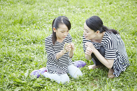 草地上野餐玩耍的母女图片