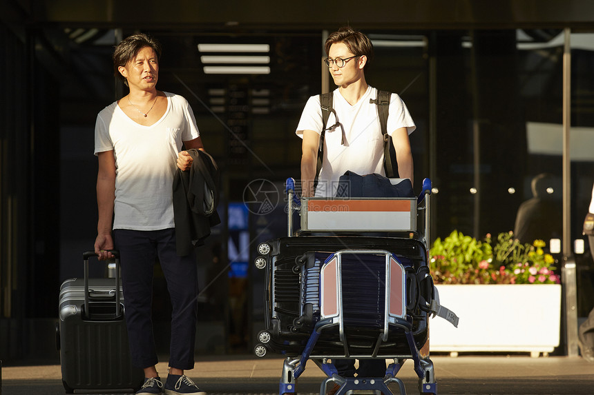 两个男人推着行李走出机场图片