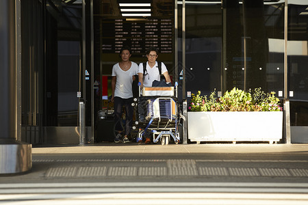 两个男人推着行李走出机场图片