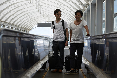 机场推行李乘坐扶梯的男人图片