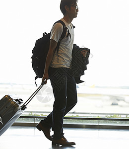 一个提行李箱的男子走在机场图片