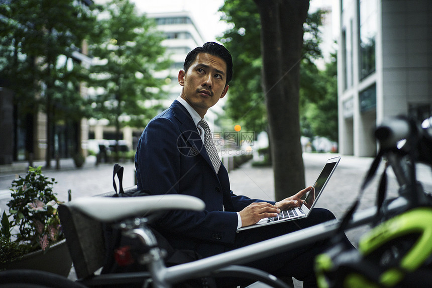 在街头用笔记本工作的男人图片