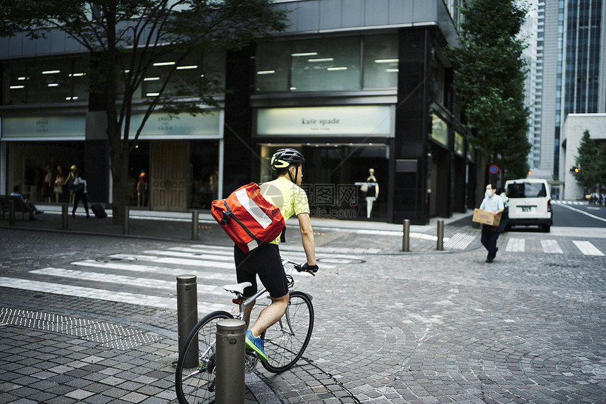 在街上骑自行车的男性图片